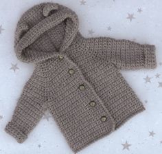 a crocheted jacket is shown on a white surface with stars in the background