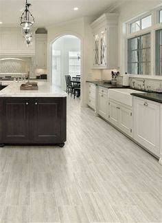 a large kitchen with white cabinets and an island in front of the stove top oven