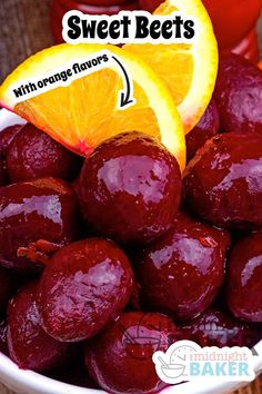 a bowl filled with oranges and beets on top of a wooden table next to an orange slice