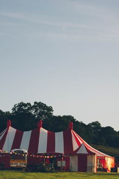 a large circus tent set up in the middle of a field