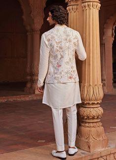 Introducing the stunning Ivory Kurta set with an Embroidered Jacket, crafted from luxurious raw silk. The ivory jacket is adorned with intricate resham, zari, zardozi, and dabka work, showcasing unique motifs that exude a regal charm. Paired with a finely detailed matching kurta and tailored pants, this outfit effortlessly combines traditional craftsmanship with contemporary design. Ideal for Haldi, Mehndi, Sangeet, or as wedding guest attire, it embodies sophistication and cultural richness, making it a timeless addition to any wardrobe. Composition : Jacket, Kurta and Pants - Raw SilkCare: Dry Clean Only and Vacuum Storage Delivery : 4-6 weeks as the product is hand crafted. Check Size Guide or choose MySize for free customisation (All Sizes above XL can be made at 15% additional cost) F Off White Raw Silk Set With Intricate Embroidery, Cream Embroidered Raw Silk Sets, Embroidered Cream Raw Silk Sets, Off White Bandhgala With Intricate Embroidery For Designer Wear, Designer Off-white Bandhgala With Intricate Embroidery, Beige Bandhgala With Chikankari Embroidery In Raw Silk, Cream Embroidered Straight Kurta Bandhgala, Designer Cream Embroidered Bandhgala, Silk Nehru Jacket With Intricate Embroidery For Reception