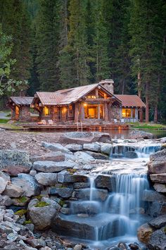 a log cabin with a waterfall running through it