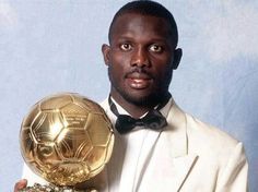 a man in a tuxedo holding a soccer ball