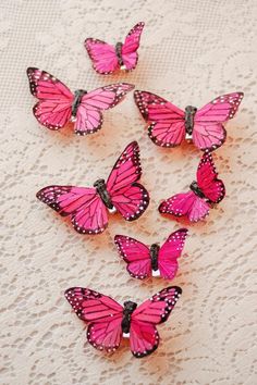 six pink butterflies sitting on top of a table