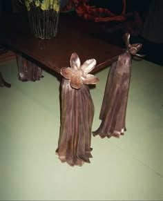 a wooden table topped with metal tassels on top of it