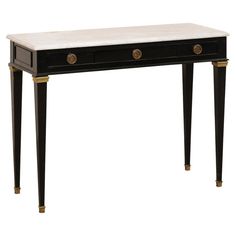 A French painted console table with drawers and its original marble top. This vintage table from France features a 39" long white marble top which rests above a recessed panel apron that houses three small drawers, set in horizontal fashion, along its front side. Each drawer is fitted with round brass pulls. The table is raised on four slender squared legs that taper gently and terminate into square-shaped brass feet. The brass and white marble are complimentary to the black finish. Please note Painted Console Table, Nashville House, French Console Table, Black Console Table, Console Table With Drawers, Table With Drawers, Black Console, Brass Pulls, Small Drawers