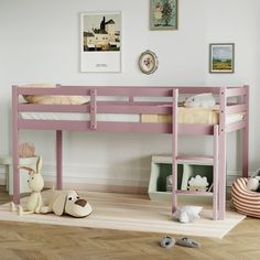 a pink bunk bed sitting on top of a wooden floor next to a stuffed animal