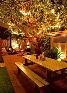 a wooden table under a tree with lights on it