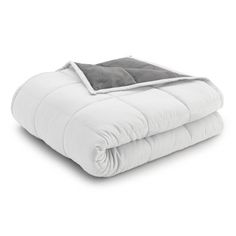 the comforter is white and grey with a gray blanket on top, it's folded up