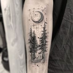 a black and white photo of a forest with a half moon tattoo on the arm