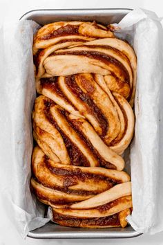 cinnamon buns wrapped in wax paper in a pan