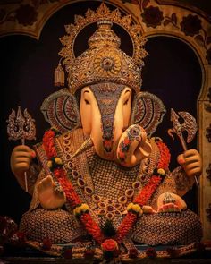 an elephant statue is adorned with gold and red decorations