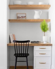 a black chair sitting in front of a wooden desk