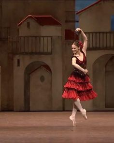 a woman in a red dress is dancing