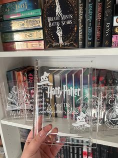 a person is holding up a harry potter book case