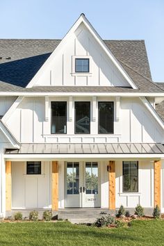 a white house with wood trim and windows on the front door is shown in this image