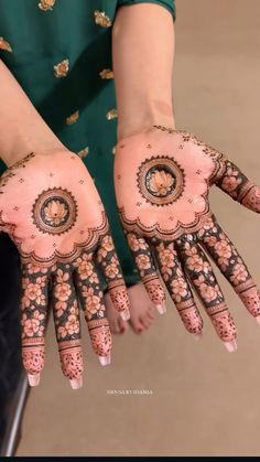 the hands are decorated with henna designs on it's palms and palm tips