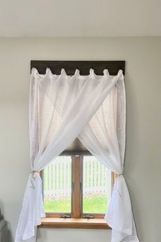 a window with white curtains hanging over it