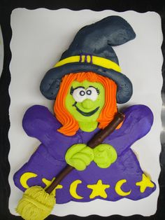 a cake decorated to look like a witch holding a broom