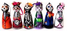 the day of the dead figurines are lined up in a row on a white background