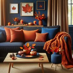 a living room filled with furniture and fall leaves on the table in front of it