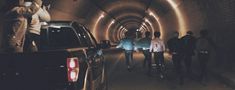 several people are walking through a tunnel