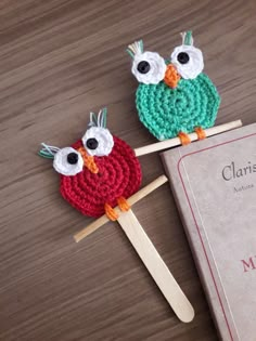 two crocheted owls sitting on top of a book