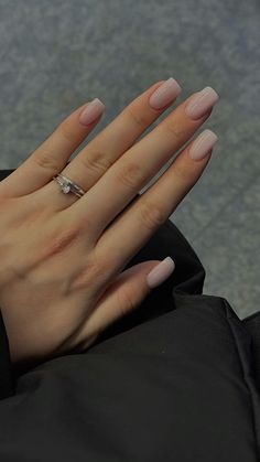 a woman's hand with long nails and a ring on her left wrist, sitting in an airport