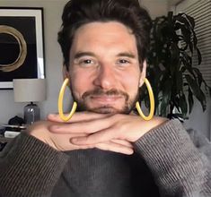 a man with large yellow hoop earrings on his face