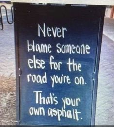 a sign that says never flame someone else for the road you're on that's your own asphalt