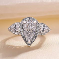 an engagement ring with three pear shaped diamonds