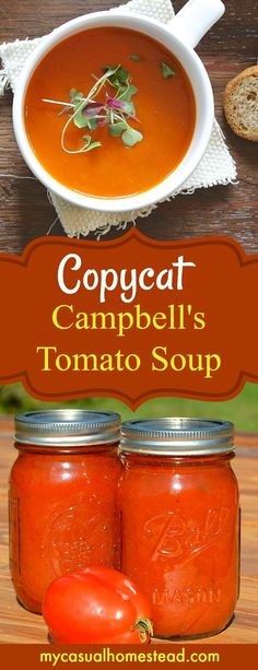 two jars filled with tomato soup on top of a wooden table next to bread and tomatoes