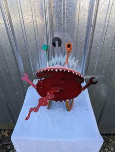 there is a sculpture made to look like a crab with tools in it's mouth