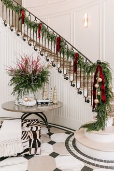 a staircase decorated for christmas with greenery and ornaments