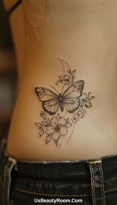 a woman's stomach with a butterfly and flowers tattoo on her side ribcage