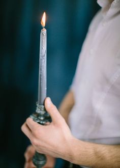 a man holding a lit candle in his hand