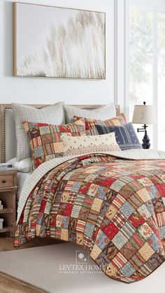 a bedroom with a large bed covered in colorful quilts and pillows next to a window