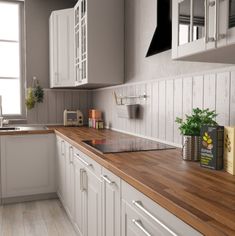 a kitchen with wooden counter tops and white cabinets