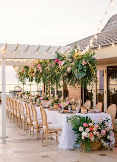 an outdoor dining area with tables and chairs set up for a formal function at the beach