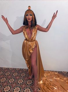 an image of a woman dressed up in gold and posing for the camera with her arms outstretched