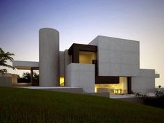 a large white building sitting on top of a lush green field