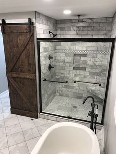 a bathroom with a tub, shower and sliding glass door