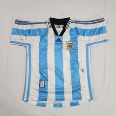 a blue and white soccer jersey on display