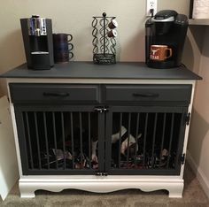 the dog is in his cage under the coffee maker