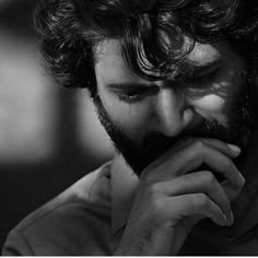 black and white photograph of a man with his hand on his chin looking at something