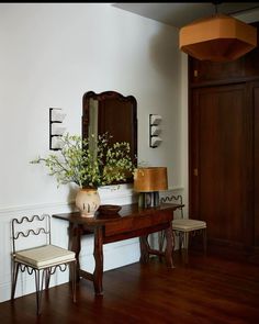 a wooden table sitting next to a mirror on top of a wall