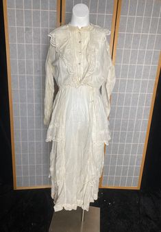 "Turn of the century off white cotton lawn dress with eyelets and glass ball buttons. Has a few stain spots, shown in photos. Also has 2 repairs. Wearable with care! Being sold as is Womens small 38\" bust 26\" waist 40\" max hips 14\" shoulder to waist 35\" waist to hem" Vintage Victorian Dress With Broderie Anglaise For Wedding, Vintage Victorian Wedding Dress With Broderie Anglaise, White Victorian Cottagecore Dress For Daywear, Vintage White Victorian Dress With Broderie Anglaise, Victorian Daywear Dresses With Buttons, Vintage White Victorian Dress For Spring, White Vintage Prairie Dress For Daywear, Spring Vintage White Victorian Dress, White Victorian Prairie Dress With Ruffles