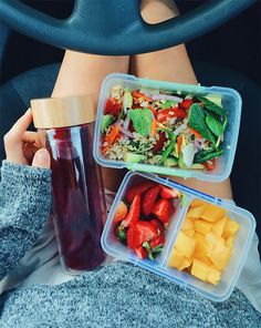 two plastic containers filled with food sitting on top of a car seat next to a woman's legs