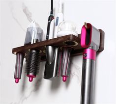 several different types of hair dryers and combs hanging on a wall with marble background