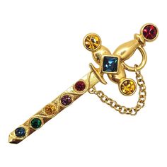 This is part of Chairish’s Costume Jewelry assortment.  Goldtone square cut faux-sapphire at the hilt with round faux-garnet, citrine amethyst and emerald sword with change brooch with security clasp. Marked "Napier" in script. Measures: 3 1/4 inches by 1 1/4 inches. Excellent condition. From Napier's 1991 Royalton limited edition line. Chanel Flower, Bakelite Brooch, Van Cleef And Arpels, Gold Brooches, Georg Jensen, Square Cut, Vintage Costume Jewelry, Jewel Tones, Vintage Costumes